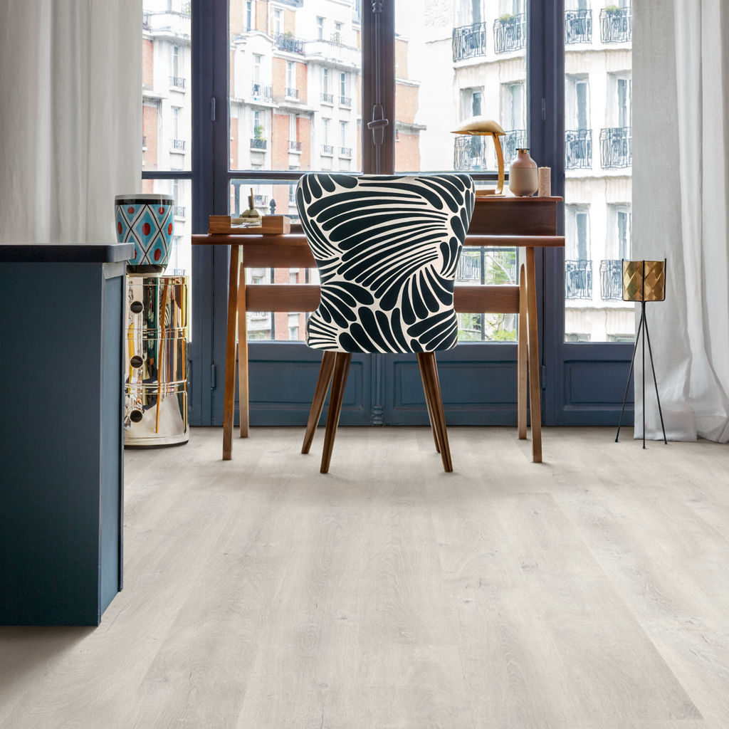 Salón parisino con suelo laminado Quick-Step Eligna Roble Venecia Claro y escritorio vintage