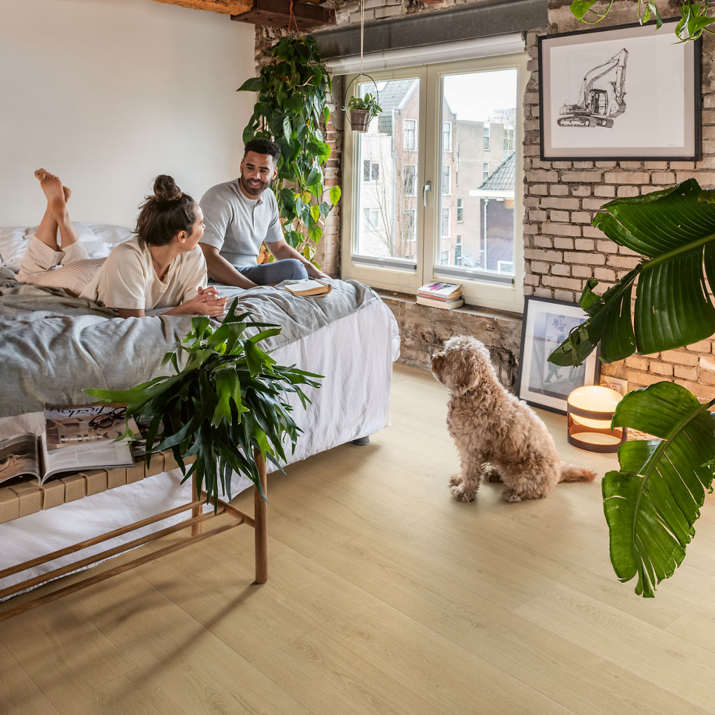 Loft con suelo laminado Quick-Step Roble Natural Cepillado, pareja relajada y su perro