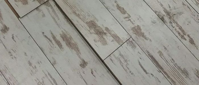 Suelo laminado con cejas y levantamiento en las juntas causado por la humedad