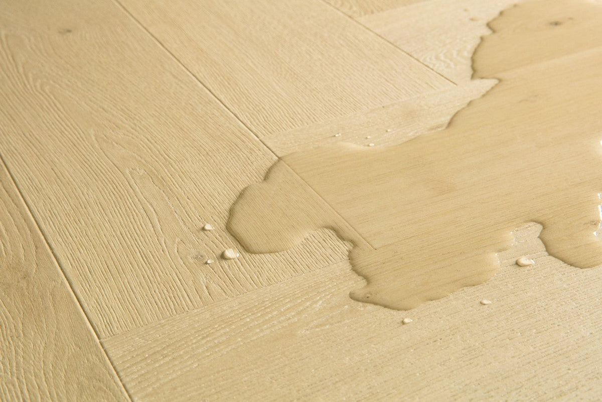 Suelo laminado Quick-Step resistente al agua con gotas sobre la superficie, para baños y cocinas