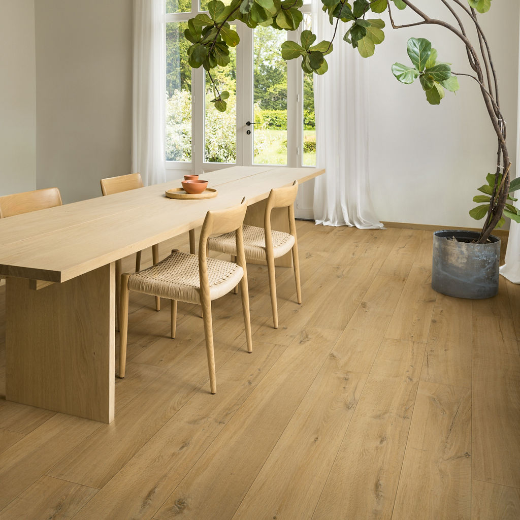 Comedor luminoso con suelo laminado Quick-Step Roble Suave Natural y gran ventanal