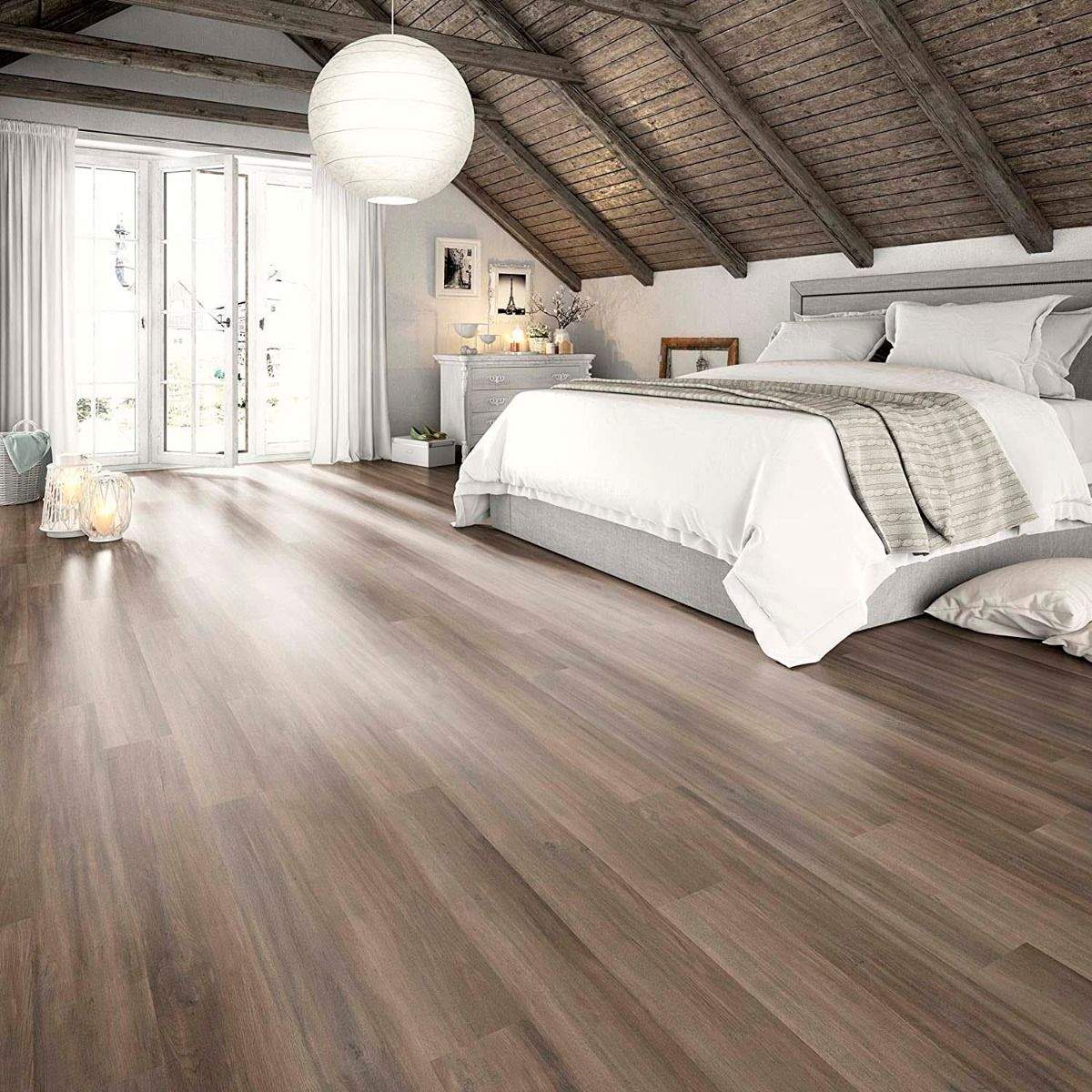 Dormitorio abuhardillado con vigas de madera y suelo laminado en tono grisáceo moderno