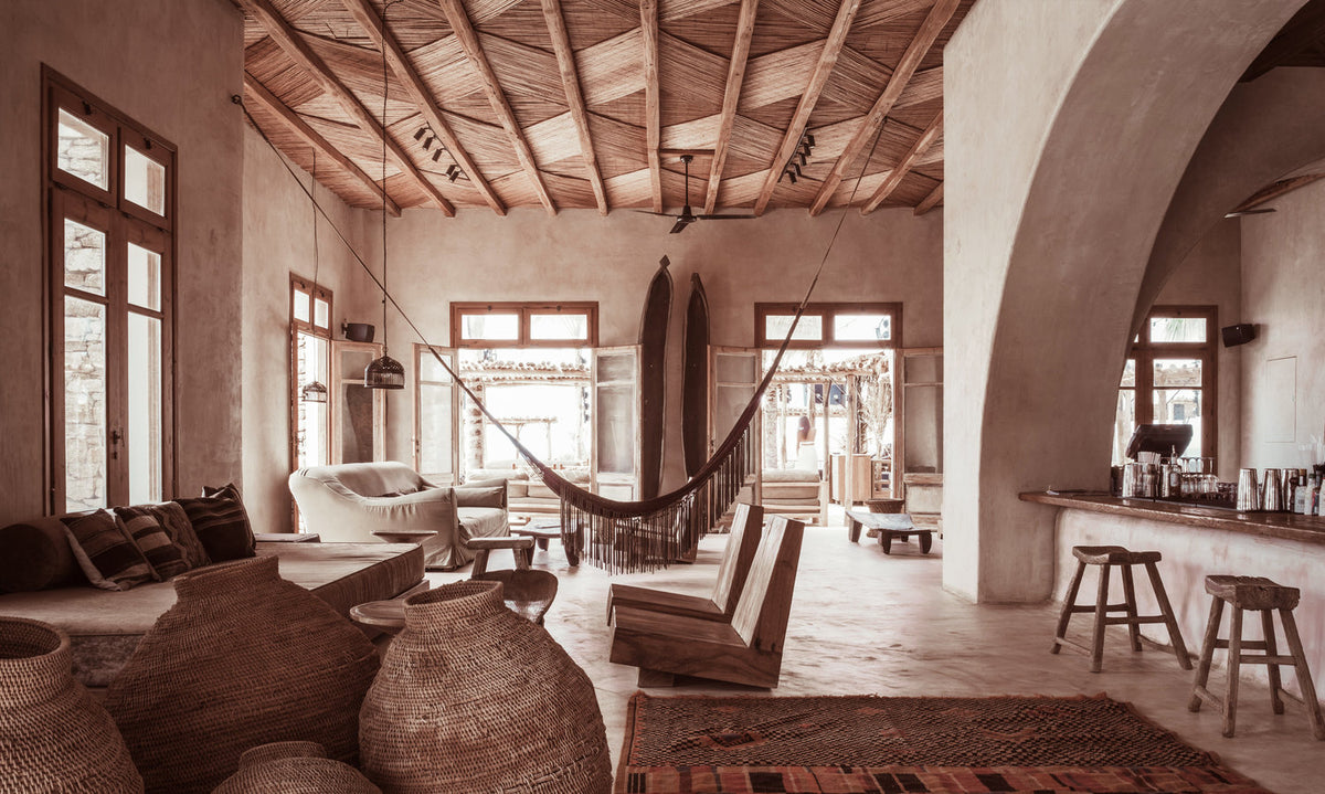 Salón de estilo boho chic con techo de madera trenzada, textiles étnicos y ambiente cálido