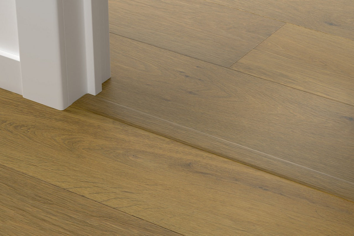 Perfil Quick-Step Incizo a juego de la tarima de madera, colocado bajo una puerta (ejemplo en un roble natural)