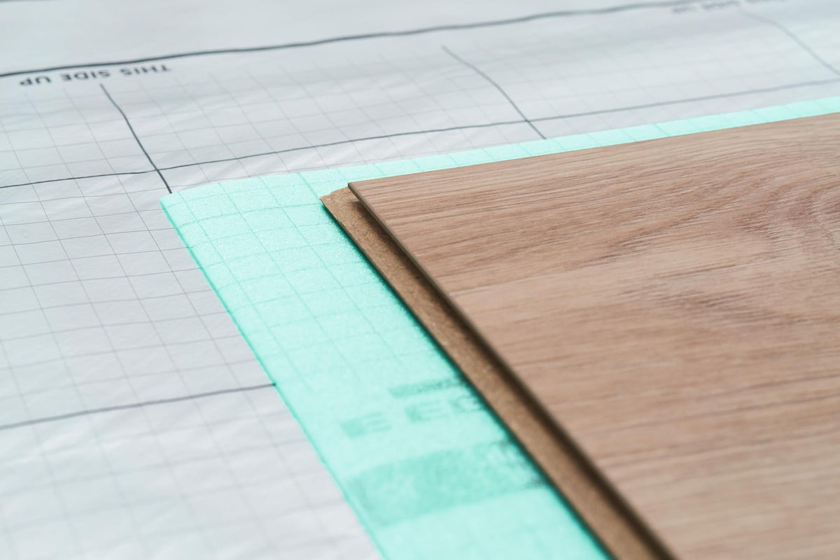 Lama de suelo laminado sobre la base EGGER Silenzio Easy, colocada encima de una lámina barrera de vapor